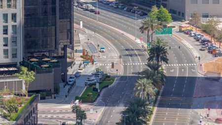 Foto de Vista panorámica del tráfico en la calle Al Saada cerca del distrito DIFC en Dubai, Emiratos Árabes Unidos. Rascacielos en el centro financiero vista aérea desde arriba con sombras moviéndose rápido - Imagen libre de derechos