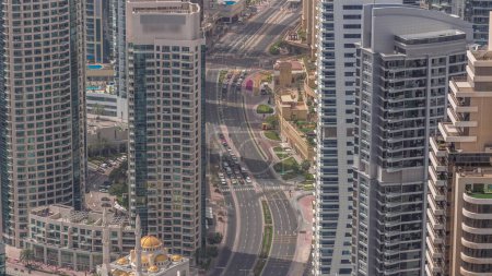 Téléchargez les photos : Vue aérienne des gratte-ciel JBR et Dubai Marina et des bâtiments de luxe d'en haut. Tours modernes avec de longues ombres se déplaçant rapidement le matin et la circulation routière - en image libre de droit