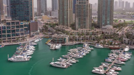 Foto de Bahía de yates de lujo en la antena de la ciudad en el puerto deportivo de Dubai en la mañana después del amanecer. Rascacielos modernos a lo largo del paseo marítimo y barcos flotando en el puerto - Imagen libre de derechos