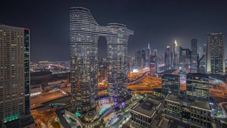 Foto de Panorama showing futuristic Dubai Downtown and finansial district skyline aerial night . Many illuminated towers and skyscrapers with traffic on streets - Imagen libre de derechos