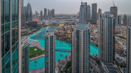 Photo for Dubai downtown with fountains and modern futuristic architecture aerial night to day transition . Panoramic view to skyscrapers with old town and shopping mall - Royalty Free Image