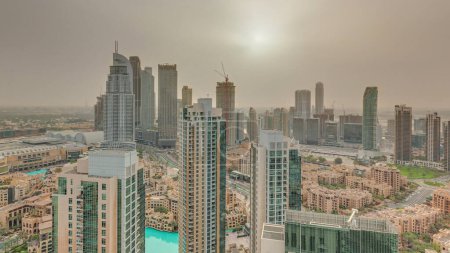 Foto de Aerial panoramic sunrise over big futuristic city . Business bay and Downtown district with skyscrapers and traditional houses. Hazy sky in Dubai, United Arab Emirates skyline. - Imagen libre de derechos