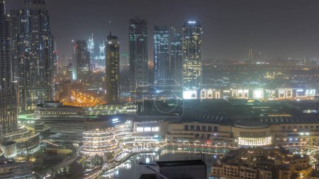 Photo for Dubai downtown with fountains and modern futuristic architecture aerial during all night . View to skyscrapers under construction with shopping mall. Lights turning off - Royalty Free Image