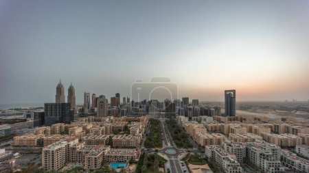 Photo for Panorama of skyscrapers in Barsha Heights district and low rise buildings in Greens district aerial night to day transition . Dubai skyline with traffic on illuminated streets - Royalty Free Image
