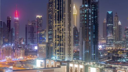 Téléchargez les photos : Row of the tall buildings around Sheikh Zayed Road and DIFC district aerial day to night transition panoramic  in Dubai, UAE. International Financial Centre skyscrapers with glass surface - en image libre de droit