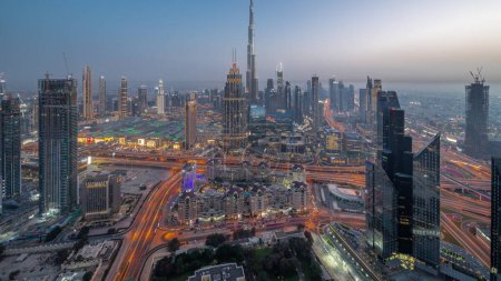 Téléchargez les photos : Vue panoramique aérienne des plus hautes tours de Dubaï Skyline du centre-ville et transition jour-nuit de l'autoroute. Quartier financier et zone d'affaires dans une ville urbaine intelligente. gratte-ciel et immeubles de grande hauteur - en image libre de droit