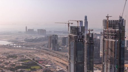 Foto de Dubai centro con la construcción a gran escala de un complejo residencial con vistas a la construcción de grúas aéreas. Gran intersección de carreteras con el tráfico temprano en la mañana - Imagen libre de derechos