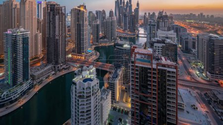 Foto de View of various skyscrapers in tallest recidential block in Dubai Marina aerial night to day transition panoramic  with artificial canal. Many towers in JBR district and yachts before sunrise - Imagen libre de derechos