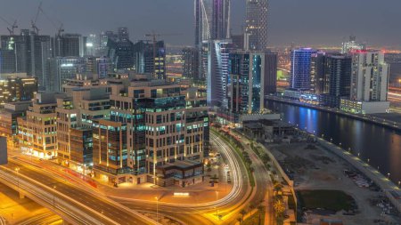 Téléchargez les photos : Quartier Bay Square transition du jour à la nuit. Immeubles à usage mixte et immeubles de bureaux complexes de faible hauteur situés à Business Bay à Dubaï. Vue aérienne d'en haut avec la circulation sur la route - en image libre de droit