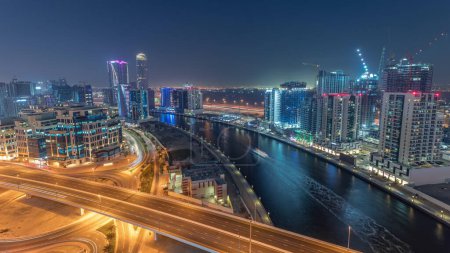 Téléchargez les photos : Skyscrapers and towers at the Business Bay aerial day to night transition  in Dubai, United Arab Emirates. Panoramic view from above with canal after sunset - en image libre de droit