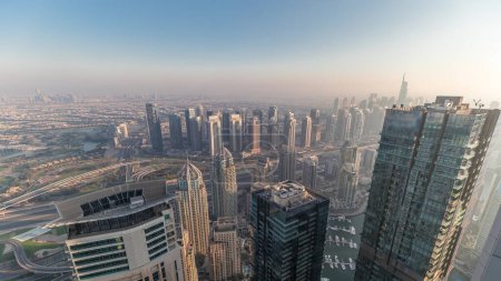Photo for Panorama of Dubai Marina with JLT skyscrapers and golf course , Dubai, United Arab Emirates. Aerial view from above towers. City skyline with hazy weather - Royalty Free Image
