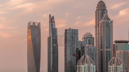 Photo for Skyscrapers of Dubai Marina with highest residential buildings  during sunset with sun reflected from a glass surface. Aerial top view from JLT district - Royalty Free Image