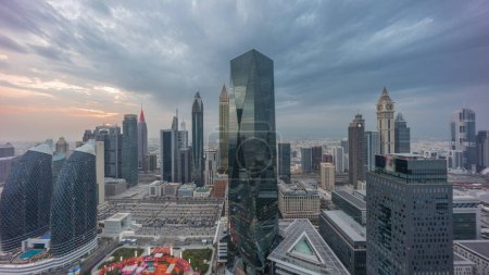 Téléchargez les photos : Panorama of futuristic skyscrapers with sunset in financial district business center in Dubai on Sheikh Zayed road . Aerial view from above with colorful cloudy sky - en image libre de droit