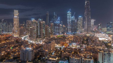 Photo for Dubai Downtown day to night transition  with tallest skyscraper and other towers around old town view from the top after sunset in Dubai, United Arab Emirates. Lights turning on. - Royalty Free Image
