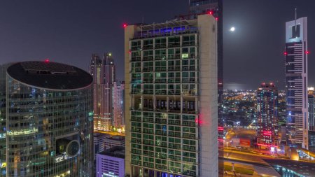 Téléchargez les photos : Dubai centre financier international gratte-ciel aérien pendant toute la nuit. Tours lumineuses avec lumières éteintes vue d'en haut. Lune couchant - en image libre de droit