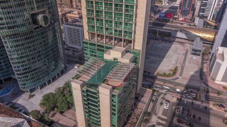 Téléchargez les photos : Dubai gratte-ciel du centre financier international avec parking matin aérien. Vue vers le bas avec de longues ombres mobiles pendant le lever du soleil - en image libre de droit