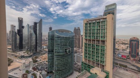 Téléchargez les photos : Panorama showing Dubai international financial center skyscrapers with promenade on a gate avenue aerial . Many office towers and traffic on a highway. Cloudy sky - en image libre de droit