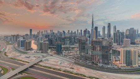 Téléchargez les photos : Skyline with modern architecture of Dubai business bay towers and downtown at sunset . Aerial panoramic view with canal and construction site - en image libre de droit