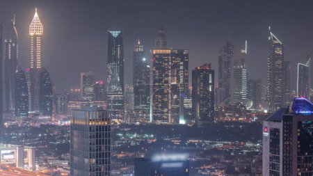 Foto de Rows of skyscrapers in financial district of Dubai aerial day to night transition . Panoramic view to many towers from Business bay district - Imagen libre de derechos