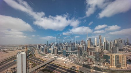 Téléchargez les photos : Skyline panoramique de Dubaï avec baie d'affaires et quartier du centre-ville avec la circulation sur la route al khail. Vue aérienne avec ombres de nombreux gratte-ciel modernes contre ciel bleu nuageux. Émirats arabes unis. - en image libre de droit