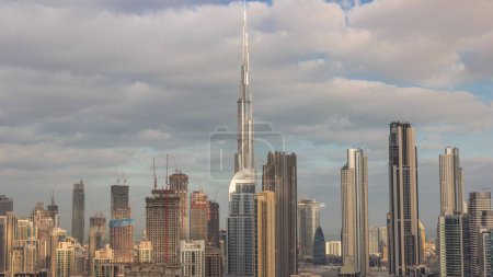 Foto de Skyline panorámico del distrito de Dubai centro con la mañana de la bahía de negocios. Vista aérea de muchos rascacielos modernos con reflejos solares durante el amanecer. Emiratos Árabes Unidos. - Imagen libre de derechos