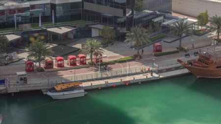 Foto de Paseo marítimo del puerto deportivo de Dubái en el paseo marítimo a lo largo del canal con la estación de transporte aéreo. Barrio residencial moderno en Dubai. - Imagen libre de derechos