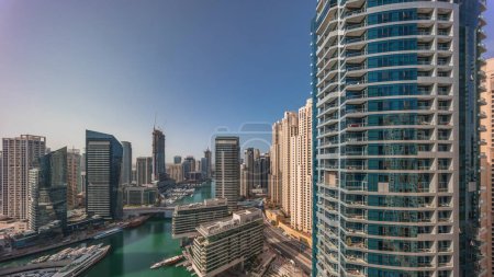 Foto de Vista aérea al puerto deportivo de Dubái y rascacielos jbr alrededor del canal con barcos flotantes panorámicos. Torres de cristal alto con ventanas y balcones. Barcos blancos están estacionados en el club de yates - Imagen libre de derechos