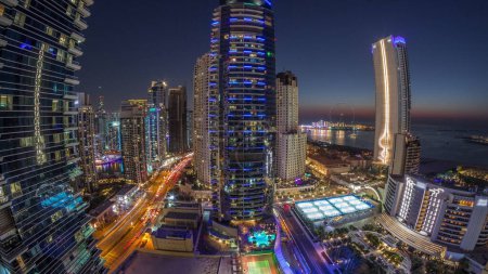 Téléchargez les photos : Panorama of the Dubai Marina and JBR area and the famous Ferris Wheel aerial day to night transition . Golden sand beaches in the Persian Gulf after sunset - en image libre de droit
