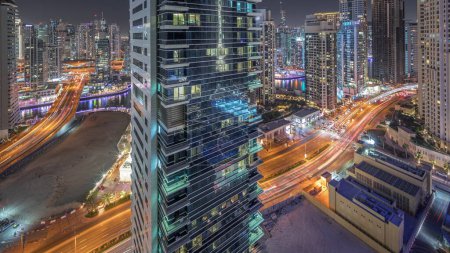 Foto de Panorama showing Dubai Marina and JBR area and the famous Ferris Wheel aerial night  and illuminated skyscrapers and traffic on streets - Imagen libre de derechos