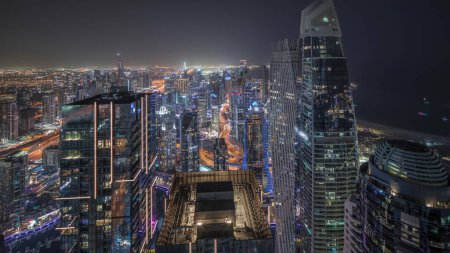 Téléchargez les photos : Panorama showing JBR district and Dubai Marina with JLT. Traffic on highway between skyscrapers aerial night . Illuminated modern towers and construction site - en image libre de droit