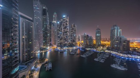 Foto de Dubai marina rascacielos más altos y yates en la antena del puerto durante toda la noche panorámica. Vista en edificios de apartamentos, hoteles y bloques de oficinas, desarrollo residencial moderno de los EAU - Imagen libre de derechos