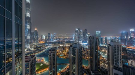 Téléchargez les photos : Dubaï centre-ville avec des fontaines et une architecture futuriste moderne aérienne pendant toute la nuit avec des lumières éteintes. Vue panoramique sur les gratte-ciel avec la vieille ville et le centre commercial - en image libre de droit