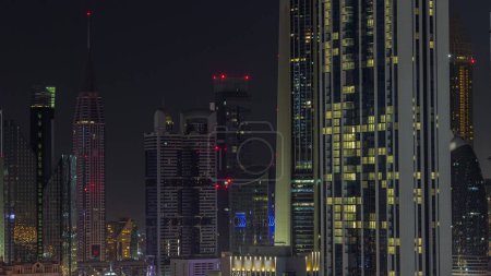 Photo for Row of the tall buildings around Sheikh Zayed Road and DIFC district aerial  during all night with lights turning off in Dubai, UAE. International Financial Centre skyscrapers with glass surface - Royalty Free Image