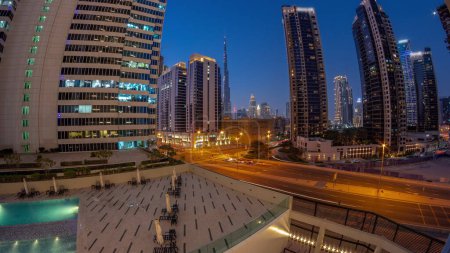 Foto de Panorama aéreo del centro de Dubái y rascacielos difc con tráfico ocupado en la intersección en el distrito de Business Bay transición día a noche . - Imagen libre de derechos