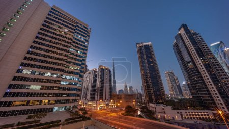Foto de Vista panorámica aérea hacia el centro de Dubái y dic rascacielos con tráfico ocupado en la intersección en el distrito de Business Bay transición día a noche . - Imagen libre de derechos