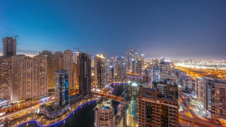Photo for Panorama of various skyscrapers in tallest recidential block in Dubai Marina aerial day to night transition  with artificial canal. Many towers in JBR district and yachts after sunset - Royalty Free Image