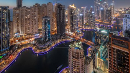Photo for View of various skyscrapers in tallest recidential block in Dubai Marina and JBR district aerial day to night transition  with artificial canal. Many towers and yachts after sunset - Royalty Free Image