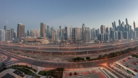 Foto de Panoraama of Dubai Marina skyscrapers and Sheikh Zayed road with metro railway aerial night to day transition . Traffic on a highway near modern towers before sunrise, United Arab Emirates - Imagen libre de derechos