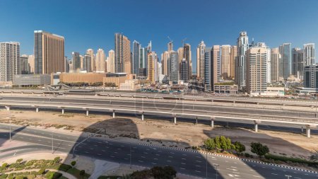 Foto de Panorama showing Dubai Marina skyscrapers and Sheikh Zayed road with metro railway aerial . Traffic on a highway near modern towers, United Arab Emirates - Imagen libre de derechos