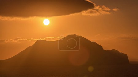 Photo for Sunset on Amorgos island aerial timelapse from above. Traditional Greece - orange sky over mountian and hills and turquoise sea, Cyclades - Royalty Free Image