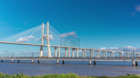Foto de The Vasco da Gama Bridge timelapse hyperlapse. Cable-stayed longest bridge flanked by viaducts and rangeviews that spans the Tagus River in Park of Nations in Lisbon, the capital of Portugal - Imagen libre de derechos