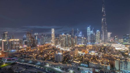Téléchargez les photos : Dubaï Panorama du centre-ville Timelapse de transition du jour à la nuit avec le plus haut gratte-ciel et d'autres tours vue du haut après le coucher du soleil à Dubaï, Émirats arabes unis. Lumières allumées. - en image libre de droit
