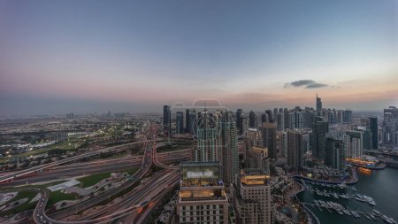 Photo for Dubai marina and JLT skyscrapers along Sheikh Zayed Road aerial day to night transition timelapse. Residential and office buildings panorama from above during sunset - Royalty Free Image