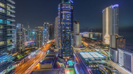 Téléchargez les photos : Vue panoramique sur le port de plaisance de Dubaï et le quartier JBR et la célèbre roue Ferris de jour à la nuit transition timelapse. Plages de sable doré dans le golfe Persique après le coucher du soleil - en image libre de droit