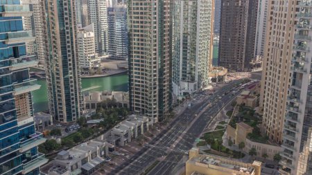 Téléchargez les photos : Vue aérienne sur les gratte-ciel de Dubai Marina et la circulation sur une route timelapse pendant toute la journée avec des ombres se déplaçant rapidement. Tours le long de la zone de marche sur un front de mer. Dubai, Émirats arabes unis - en image libre de droit