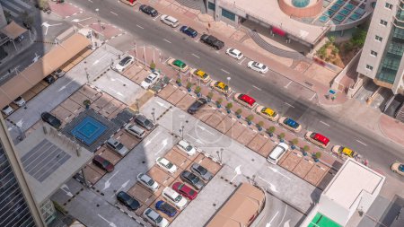 Photo for Aerial view of car crowded parking lot near apartment buildings timelapse at morning. Row of taxi cabs waiting near a road. Shadows moving fast - Royalty Free Image