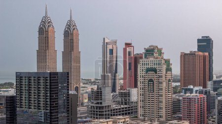 Téléchargez les photos : Des gratte-ciels dans le quartier de Barsha Heights et des tours internet de la ville aérienne nuit au jour passage timelapse. Skyline Dubaï avant le lever du soleil - en image libre de droit