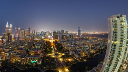 Téléchargez les photos : Panorama avec des gratte-ciel dans le quartier de Barsha Heights et des bâtiments de faible hauteur dans le quartier des Verts timelapse de transition du jour à la nuit. Skyline de Dubaï avec trafic de rue - en image libre de droit