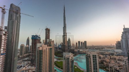 Téléchargez les photos : Dubaï Paysage urbain du centre-ville avec les plus hauts gratte-ciel autour de la nuit aérienne à la transition de jour timelapse panoramique. Site de construction de nouvelles tours et de routes achalandées avec trafic d'en haut - en image libre de droit