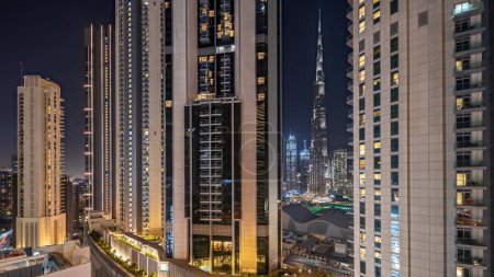 Photo for Panorama showing tallest skyscrapers during Earth hour in downtown dubai located on bouleward street near shopping mall aerial night timelapse. Lights turning off for one hour - Royalty Free Image